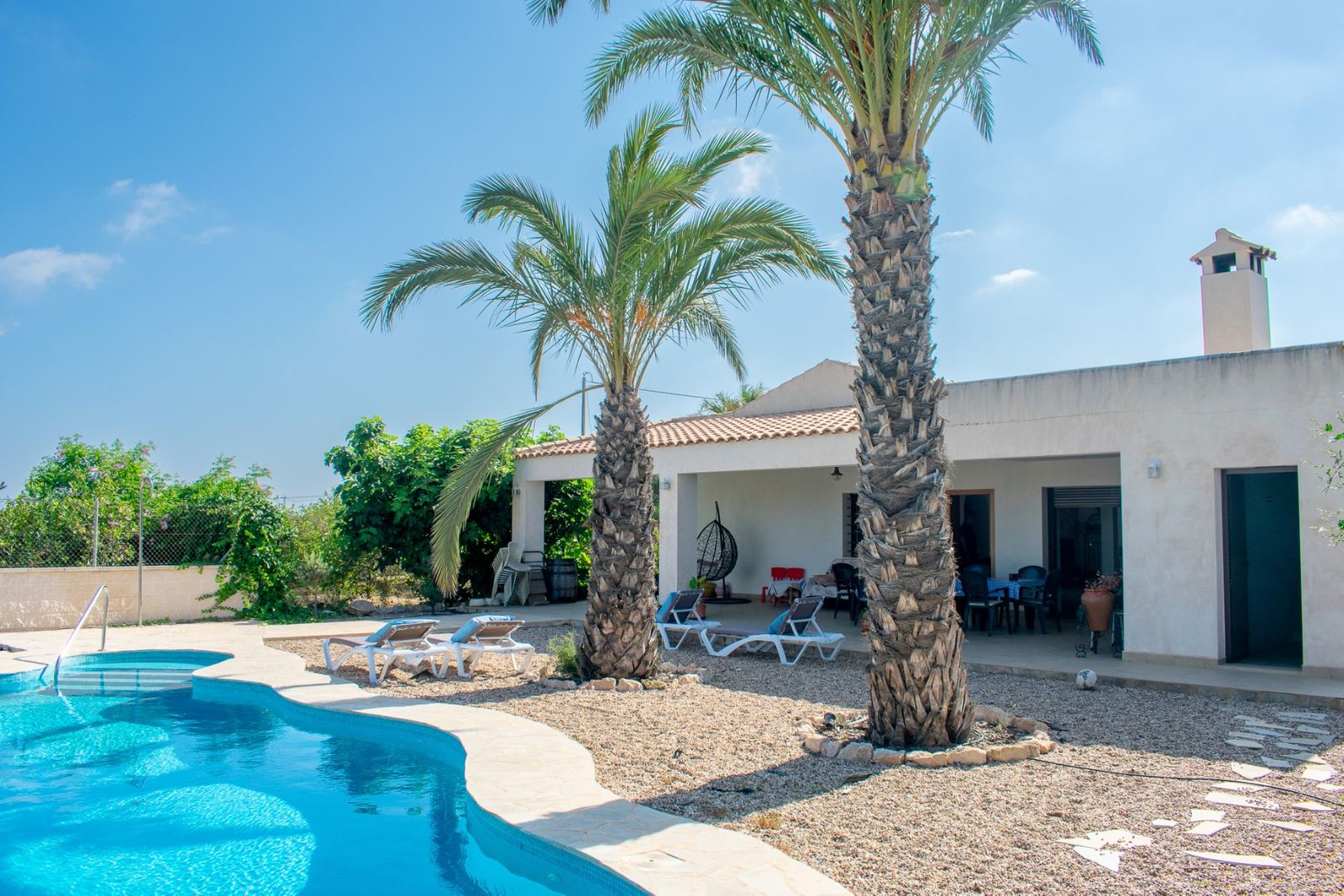 Villa met zwembad en palmbomen in de tuin