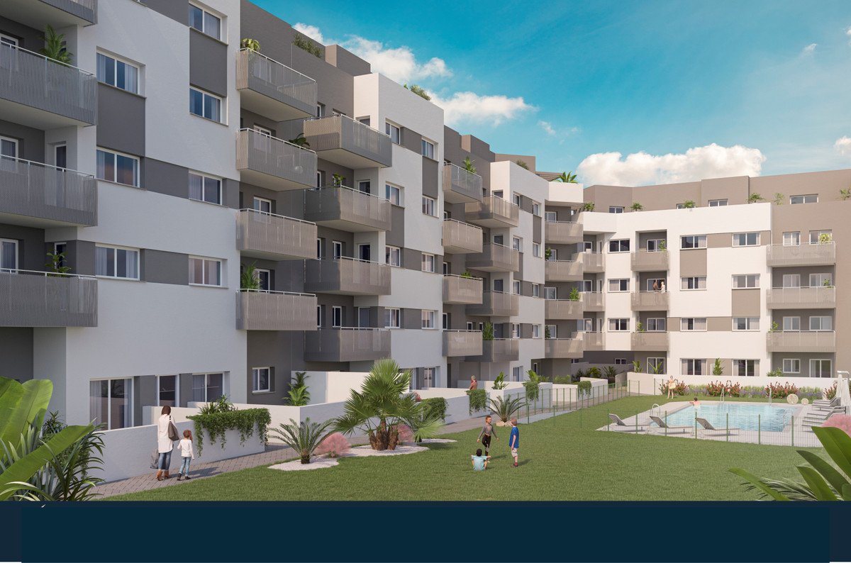 Moderne boligkompleks med balkoner, pool og grønne områder under blå himmel.