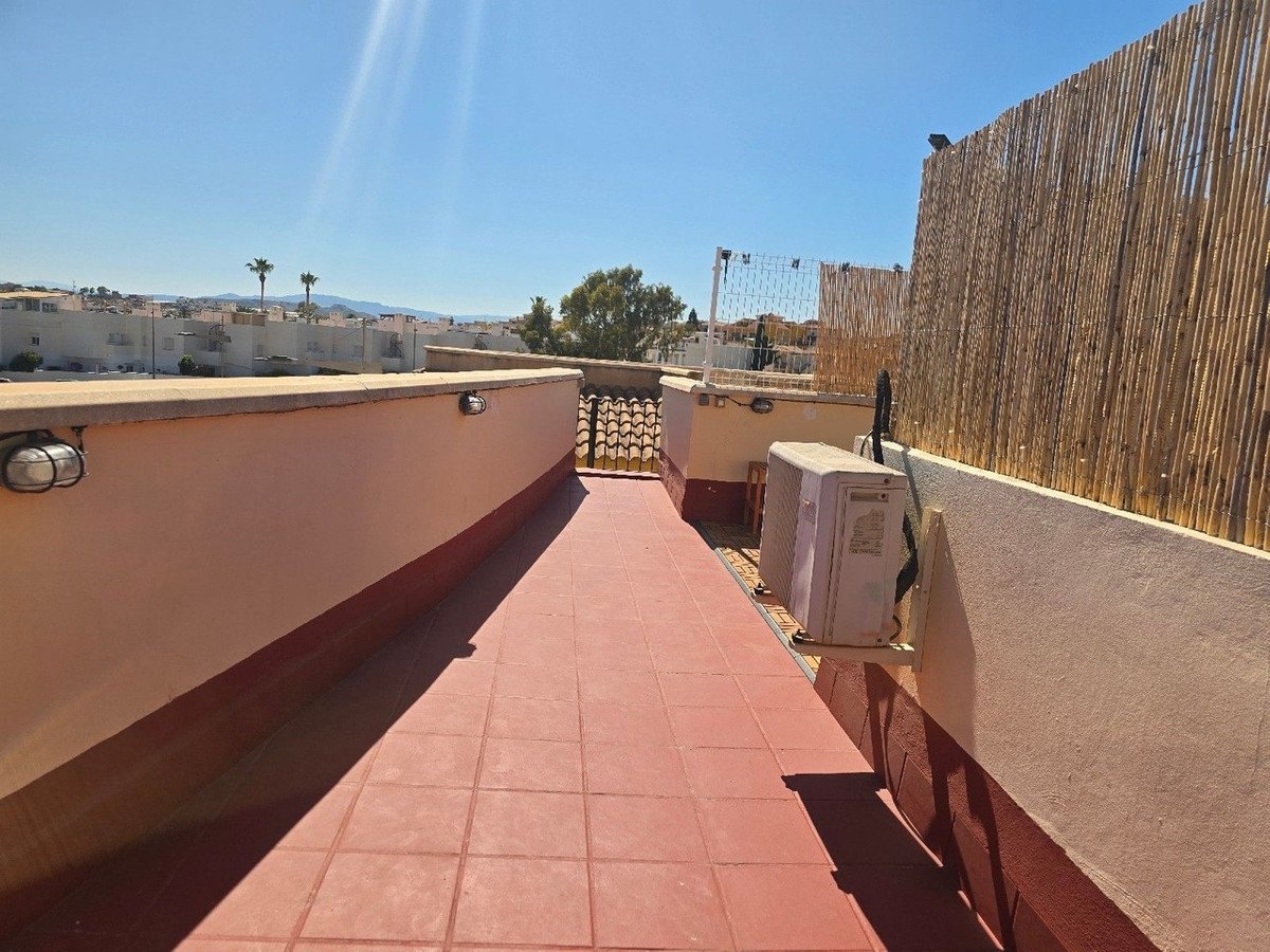 Rooftop terrace with tiled flooring, privacy screen, and distant views
