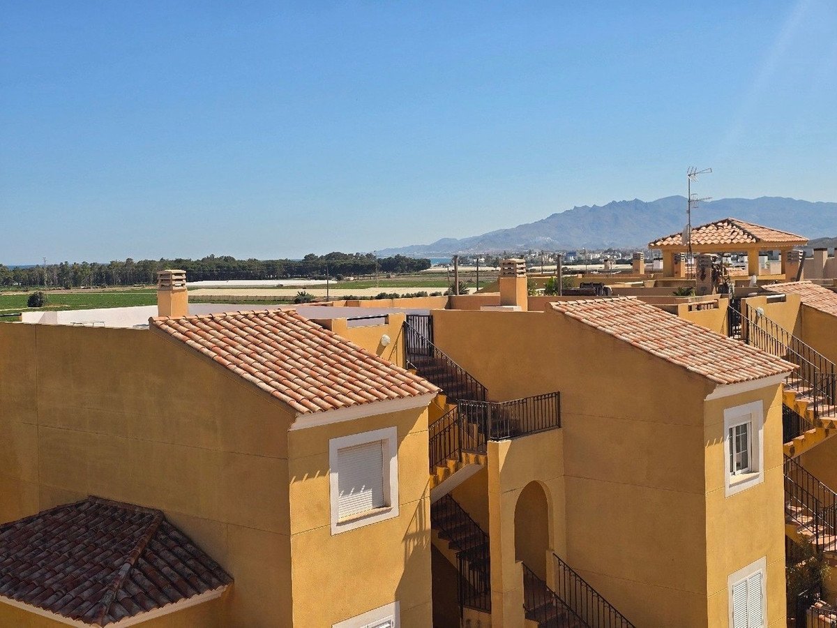 Rooftop view of yellow apartment buildings with mountains in the distance