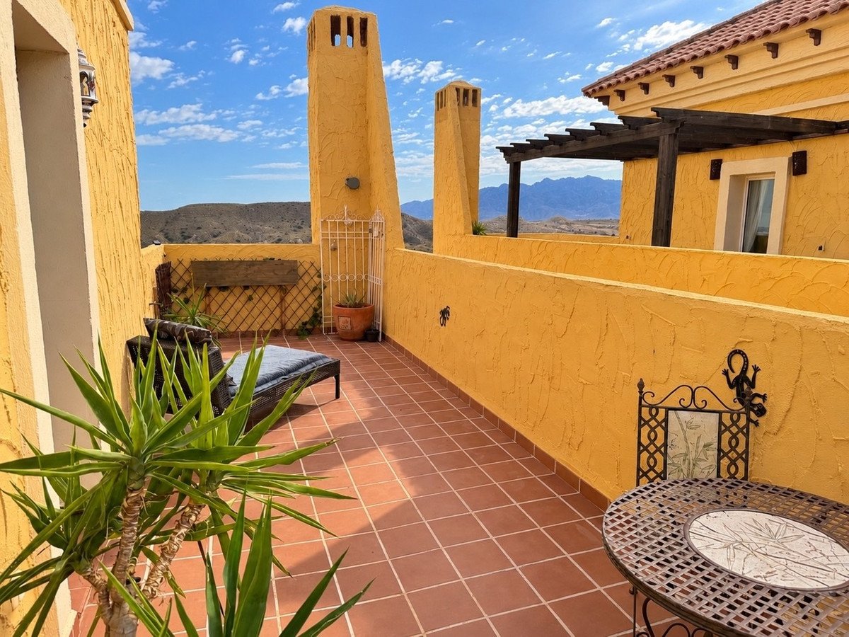 Yellow terrace with mountain view, chimneys, and outdoor seating