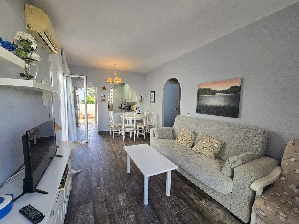 Spacious living room with open-plan dining area, sofa, and view to outdoor space