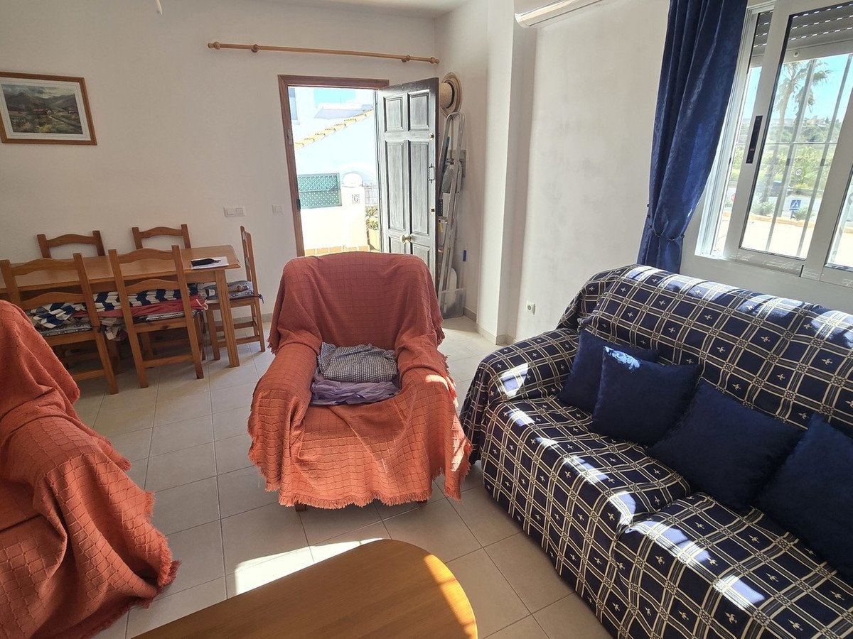 Cozy living and dining area with a sofa, armchair, dining table, and access to an outdoor patio.