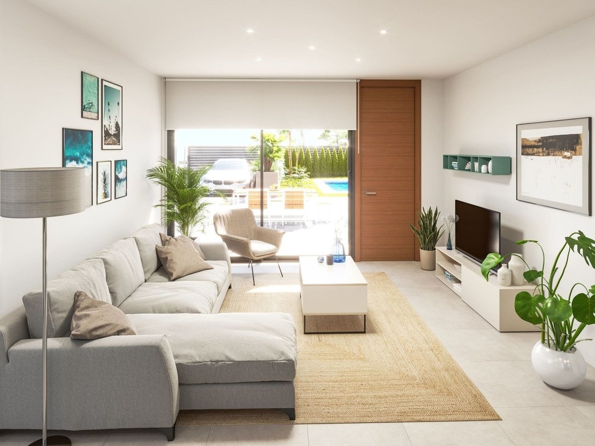 Modern living room with a sectional sofa, armchair, TV, and a large window overlooking a backyard with a swimming pool.