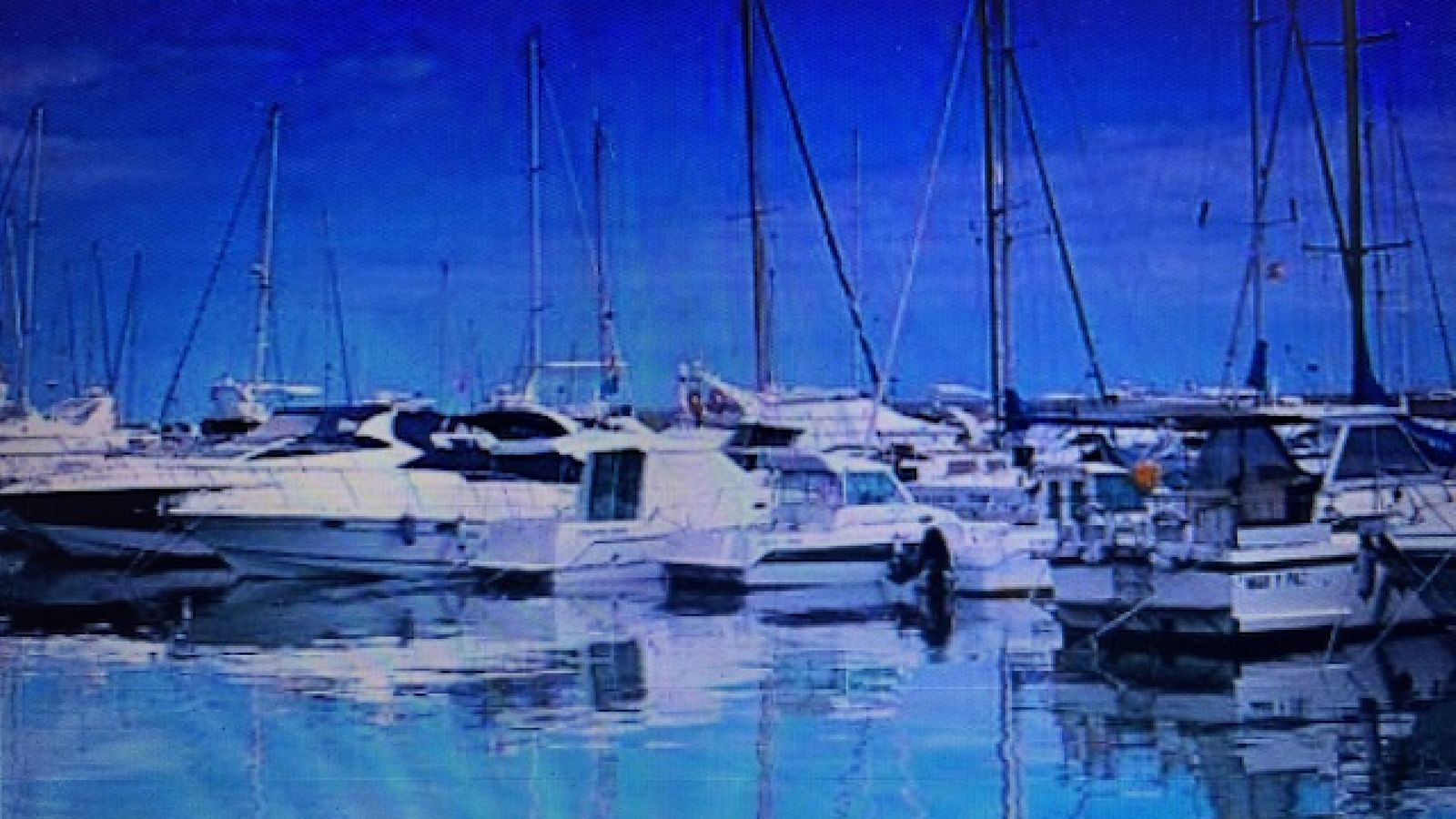 Boten in een jachthaven, reflecterend in het water.