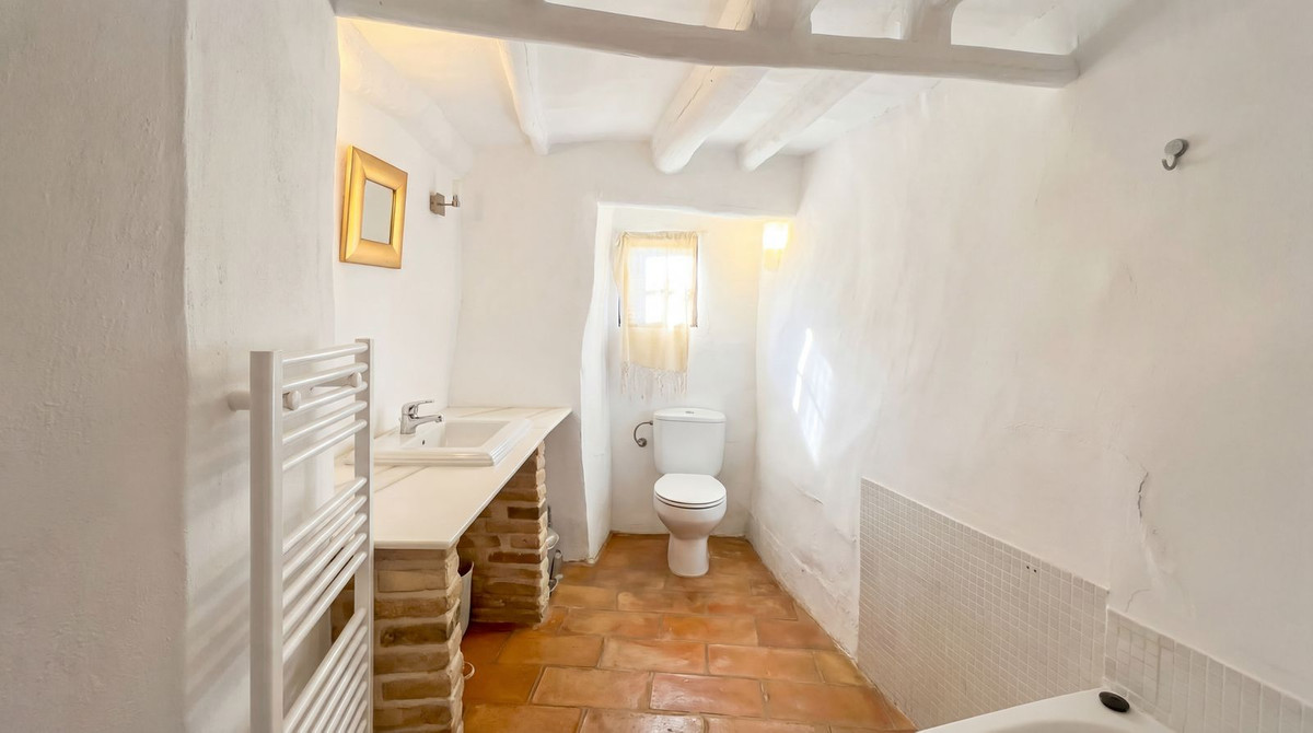 Rustieke witte badkamerinterieur met terracotta vloer